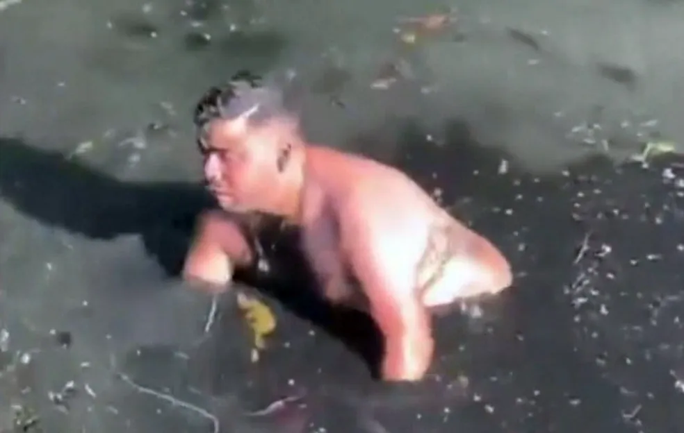 Homem pula em esgoto para encontrar celular