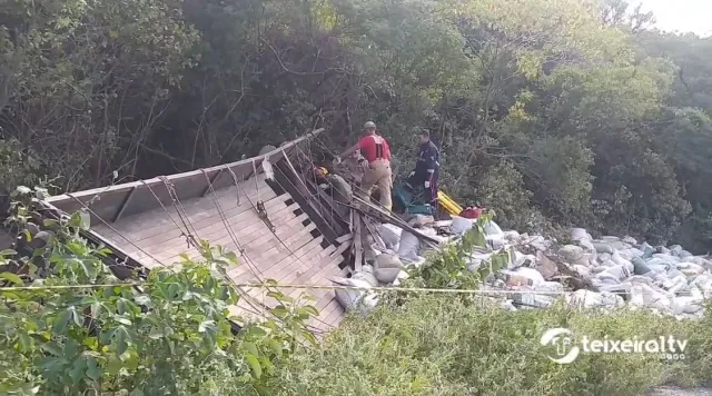 Caminhão carregado com “cama de frango” tomba e motorista fica preso às ferragens, na Serra do Teixeira