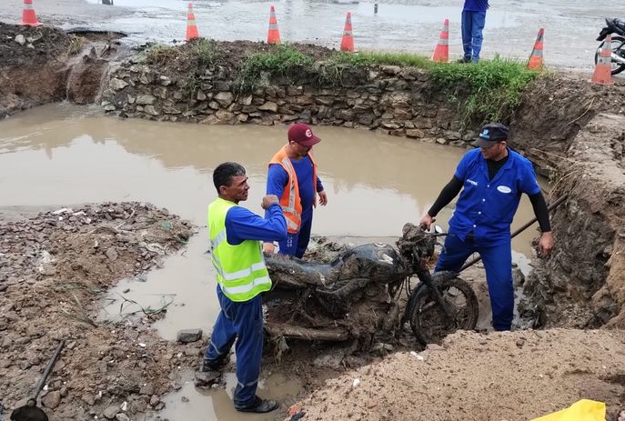 Operários retiram moto, que entupia o bueiro durante obras de desobstrução na PB
